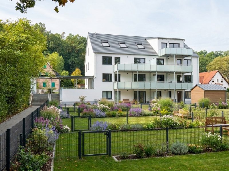Visualisierung: das Haus von der Gartenseite mit eingezäunten, bepflanzten Gartenparzellen